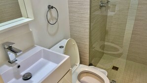 Ein Badezimmer mit Waschbecken, Toilette und Duschbereich.