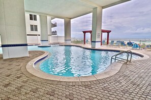 A swimming pool with a tiled deck, a covered seating area, and a view of the ocean. - Breathtaking Views in this 3 BR 2 BA in Tower 1 at the Majestic!!!! (Panama City Beach)