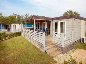 A mobile home with a porch, outdoor seating, and a small deck. - Adriatic Family Plus Retreat for 6 (Brtonigla)