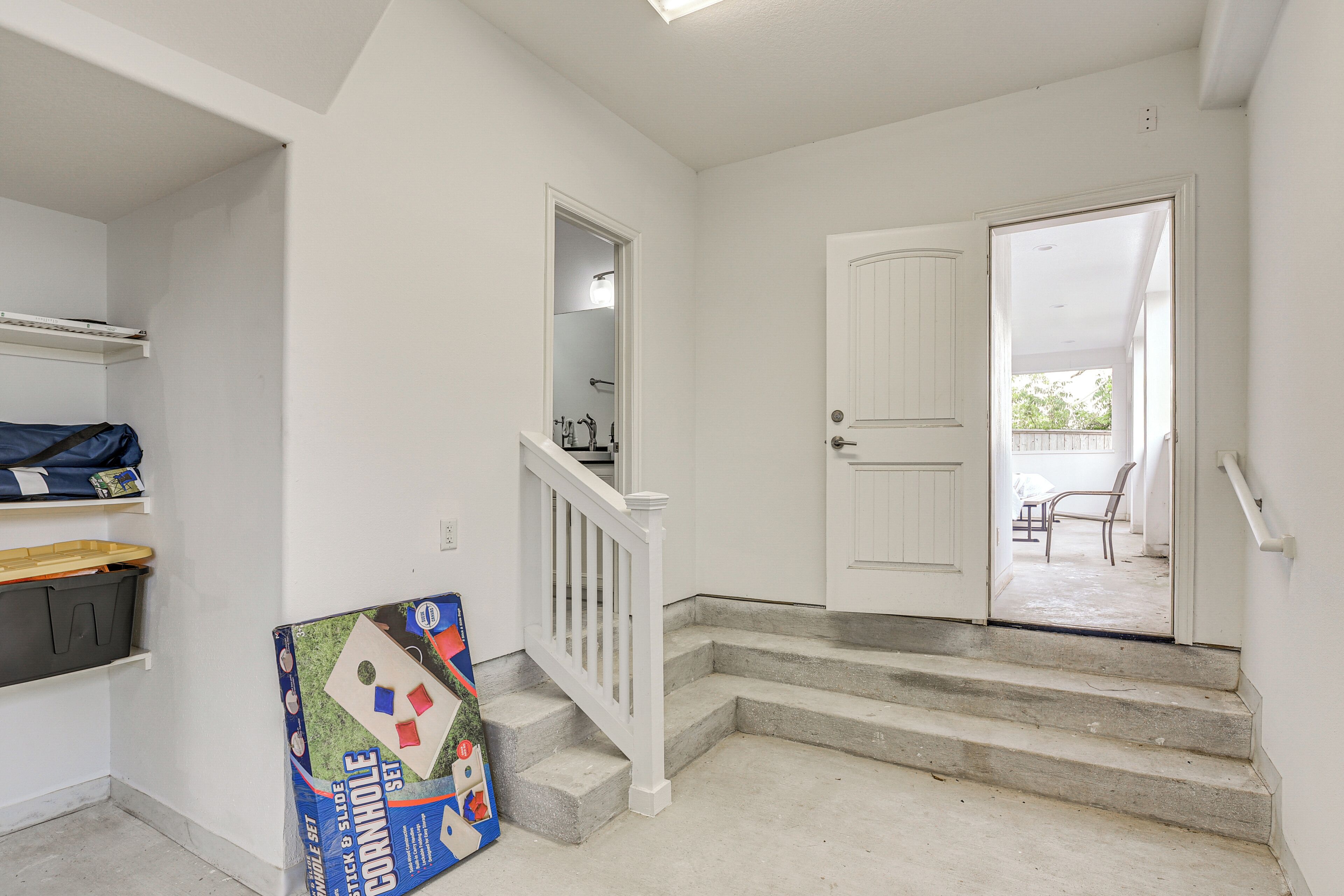 A staircase leading to a door, a storage unit, and a set of steps.