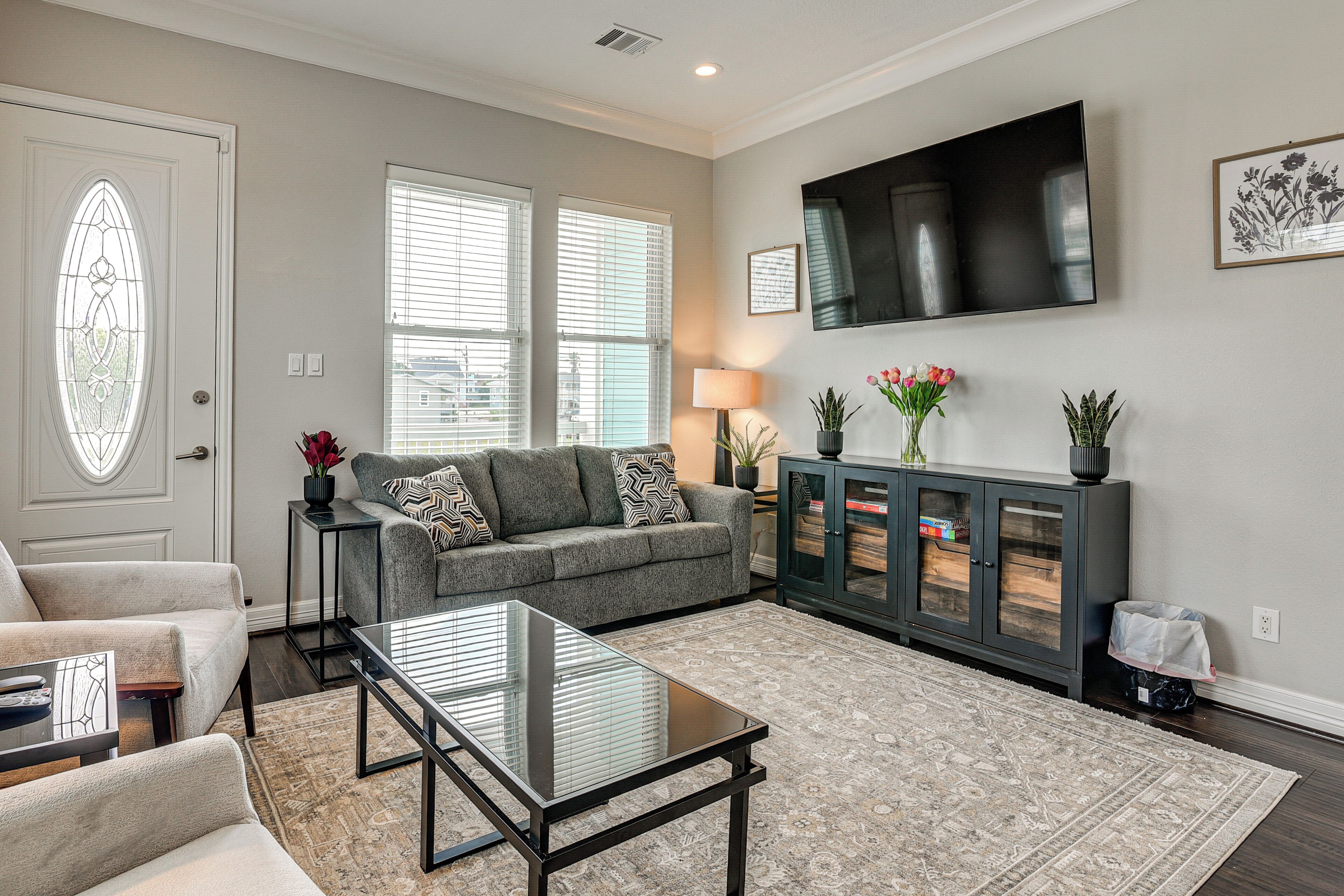 A living room with a sofa, coffee table, TV, and decorative items.