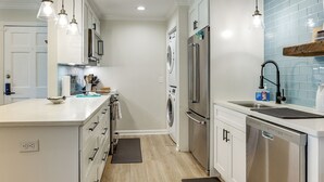 A modern kitchen with stainless steel appliances, a dishwasher, and a built-in oven. - Pool Access! St Simons Island Getaway w/ Balcony (St. Simons Island)