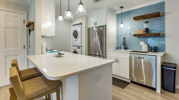 A modern kitchen with a central island, stainless steel appliances, and pendant lighting. - Pool Access! St Simons Island Getaway w/ Balcony (St. Simons Island)