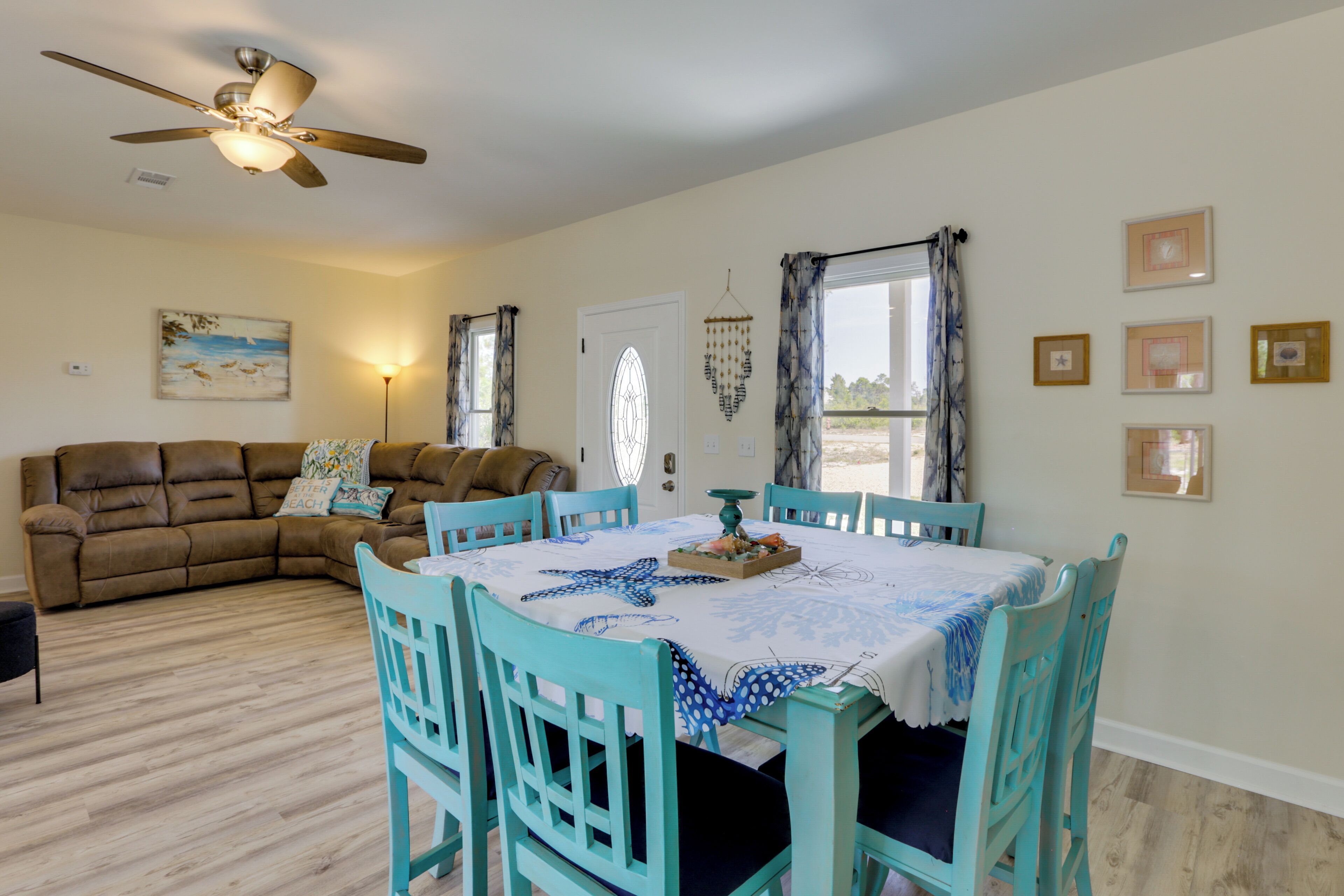 A dining area with a table set for four, surrounded by four chairs.