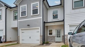 A two-story residential building with a garage, a front door, and a small porch area. - Easy Access to Golf Club & Dtwn: Augusta Basecamp (Evans)