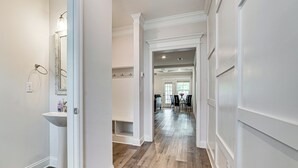 A hallway with a white sink, a mirror, and a wooden floor. - Easy Access to Golf Club & Dtwn: Augusta Basecamp (Evans)