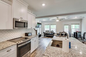 A kitchen with white cabinets, a microwave, a stove, and a large island with a sink. - Easy Access to Golf Club & Dtwn: Augusta Basecamp (Evans)