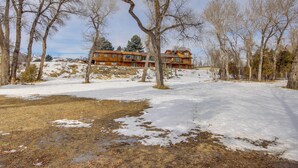 A large wooden house surrounded by snow-covered ground and leafless trees. - Emigrant Lodge w/ Spa: 3 Suites Near Yellowstone (Emigrant)