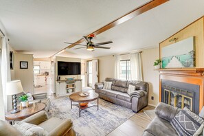 A living room with a sofa, coffee table, and a fireplace. - Walk to Silver Lake State Park! Family Getaway (Mears)