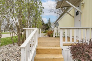A wooden deck leading to a building with a white railing, a satellite dish, and a door. - Walk to Silver Lake State Park! Family Getaway (Mears)