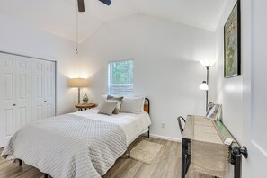 A bedroom with a bed, bedside table, lamp, window, and door. - Bring Your Boat! Cozy Home 3 Mi to Sabine River (Joaquin)