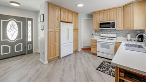 A modern kitchen with wooden cabinets, a refrigerator, a microwave, an oven, and a white countertop. - Gateway to Big Bear! High-country Home w/ Deck (Running Springs)