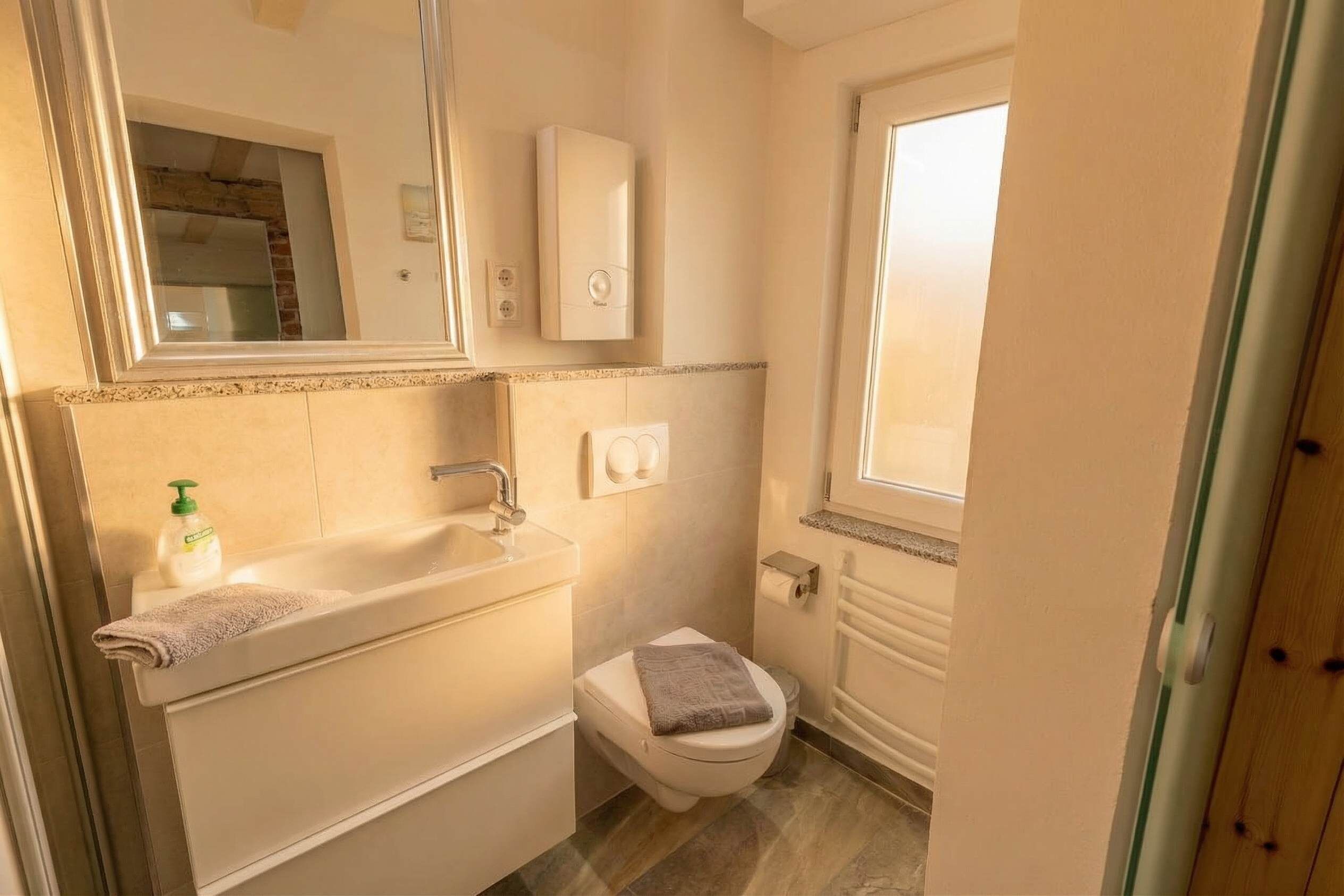A bathroom with a bathtub, toilet, and a mirror.