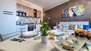 Eine moderne Küche mit Essbereich, inklusive Tisch gedeckt mit Tellern, Gläsern und einem Blumentopf.