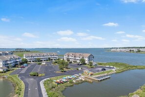 Hotel aan het water met meerdere gebouwen, een parkeerplaats en een steiger met boten.