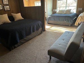 A bedroom with two beds, a sofa, and a carpeted floor. - Lake Travis waterfront escape that sleeps 16 (Spicewood)
