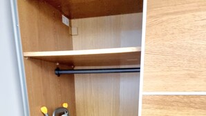 A wooden closet with a hanging rack and a towel with a leaf pattern. - 4 bedroom duplex in central London with private entrance (London)