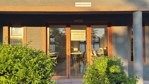 A restaurant entrance with a sign indicating operation times and a sign above the door reading 'ADMIN BLOCK.' - Raintree Hotel (Nata)