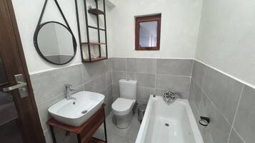 A bathroom with a sink, toilet, and bathtub.