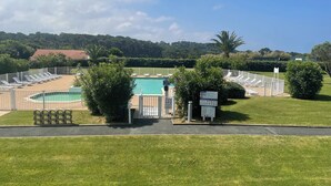 Ein Poolbereich mit Liegestühlen, einem umzäunten Pool und einem Hinweisschild.
