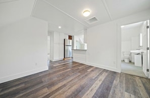 A spacious, modern apartment with a hardwood floor, white walls, a kitchen with stainless steel appliances, and a visible bathroom. - Charming Canton apartment perfect for world cup (Canton)