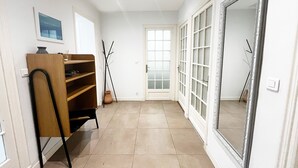 Ein Flur mit einer Holzeinrichtungsanlage, einem großen Spiegel und einer Tür mit gefrosteten Glasscheiben.