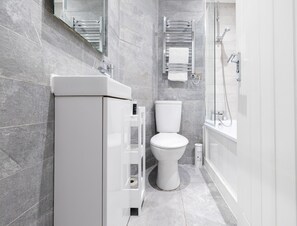 Ein modernes Badezimmer mit Toilette, Waschbecken und Dusche.
