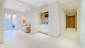 Een modern interieur met een keuken, een zithoek met een bank en een houten deur.