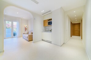 Ein modernes Interieur mit einer Küche, einem Wohnbereich mit einer Couch und einer Holztür.