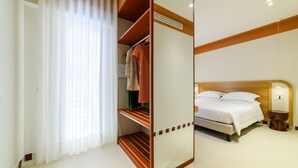 Een hotelkamer met een bed, een kledingkast, een spiegel, een nachtkastje en een raam met gordijnen.