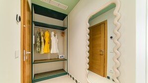 Een kamer met een kledingkast, een spiegel met een golvend frame en een deur.
