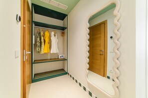 Ein Zimmer mit Kleiderschrank, Spiegel mit geschwungener Rahmen und Tür.