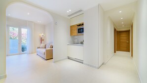 Een modern interieur met een keuken, een zithoek met een bank en een houten deur.