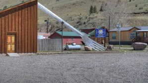 A cabin with a wooden exterior, a metal staircase, and a sign indicating 'CABS' and 'SNOWSHOE CABS.' - New Listing! Quaint Affordable Cabin | Walkable to Downtown Creede (Creede)