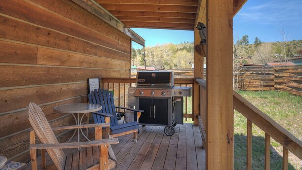 A wooden deck with a grill, a table, and two chairs. - New Listing! Quaint Affordable Cabin | Walkable to Downtown Creede (Creede)