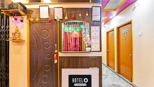 A hotel reception area with a wooden reception desk, a sign indicating 'HOTELO Company-Serviced,' and a reception counter. - Deluxe With Ganga View Green Guest House (Shrirampur)