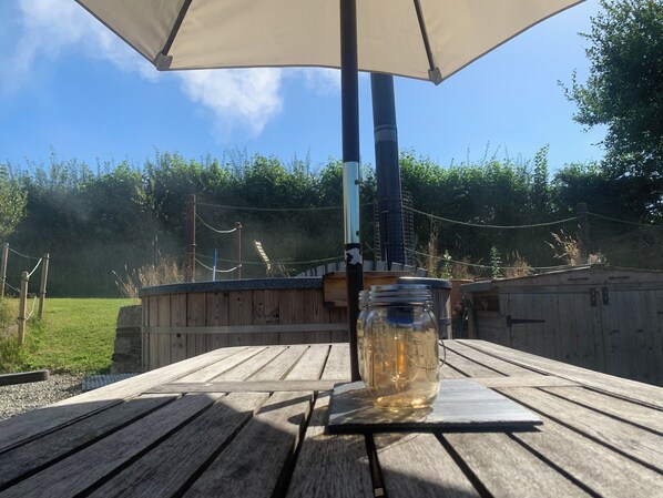 Ein Holztisch mit einem Glasbehälter, einer Metallstange und einem Baldachin.