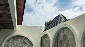 Ein Schwimmbecken mit Steinschalen und Bögen, umgeben von Pflanzen.