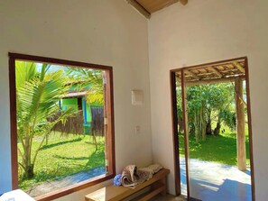 A room with a bench, a window, and a view of a garden. - House on Caraíva Beach (Caraíva)