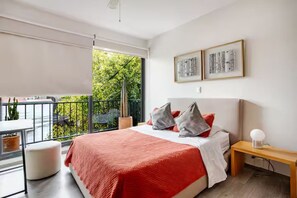 A bedroom with a bed, a bedside table, a window with a view, and a balcony. - 205-2 3 BR 2 Baths Private Terrace - Roma Norte (Mexico City)
