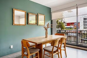 A dining area with a wooden table and chairs, three framed mirrors on the wall, and a vase with dried flowers. - 205-2 3 BR 2 Baths Private Terrace - Roma Norte (Mexico City)