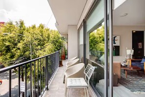 A balcony with chairs, a table, and a view of trees. - 205-2 3 BR 2 Baths Private Terrace - Roma Norte (Mexico City)