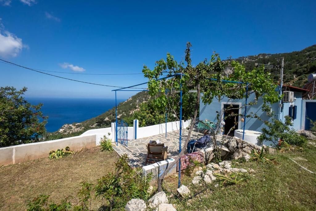 A coastal property with a stone patio, a small outdoor seating area, and a view of the sea.