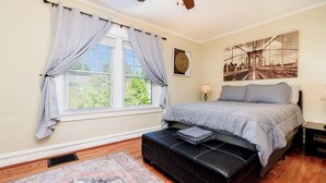 A bedroom with a bed, a window with curtains, a nightstand, a lamp, a rug, and a ceiling fan. - Beautiful 3 Story Home in Best Tower Grove Location (St. Louis)