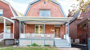 A two-story brick house with a front porch, a small garden, and a visible number '402' on the door. - Beautiful 3 Story Home in Best Tower Grove Location (St. Louis)