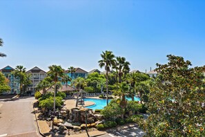 Ein Resort mit Swimmingpool, Palmen und Blick auf Hotelgebäude.