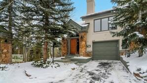 Ein Haus mit einer Stein-Fassade, einer Holztür und einer Garage.