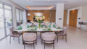 A modern dining area with a round table, six chairs, and a vase of flowers. - ANGSANALUXUREAPR (Thalang)