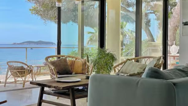 A room with a large window, wicker furniture, and a view of the sea. - Luxury villa - Les Galets (La Ciotat)