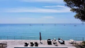 A poolside area with lounge chairs and a view of the sea. - Luxury villa - Les Galets (La Ciotat)